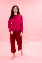 Person wearing a pink satin blouse on a pink background